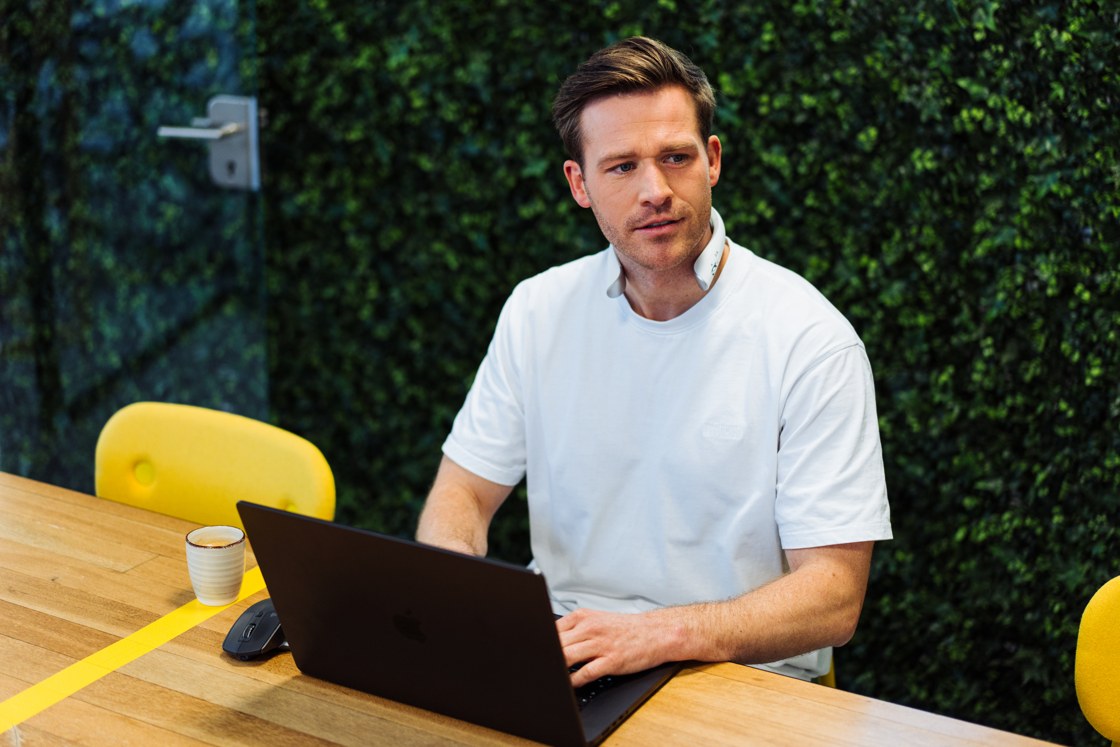 Model in an everyday work setting, not a portrait of the founder